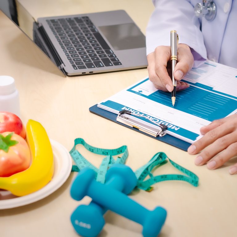 A male nutritionist sitting at a table, advising on healthy diets, promoting vegetable-based meals